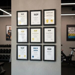 Framed personal trainer certifications on a wall, representing professional qualifications in fitness